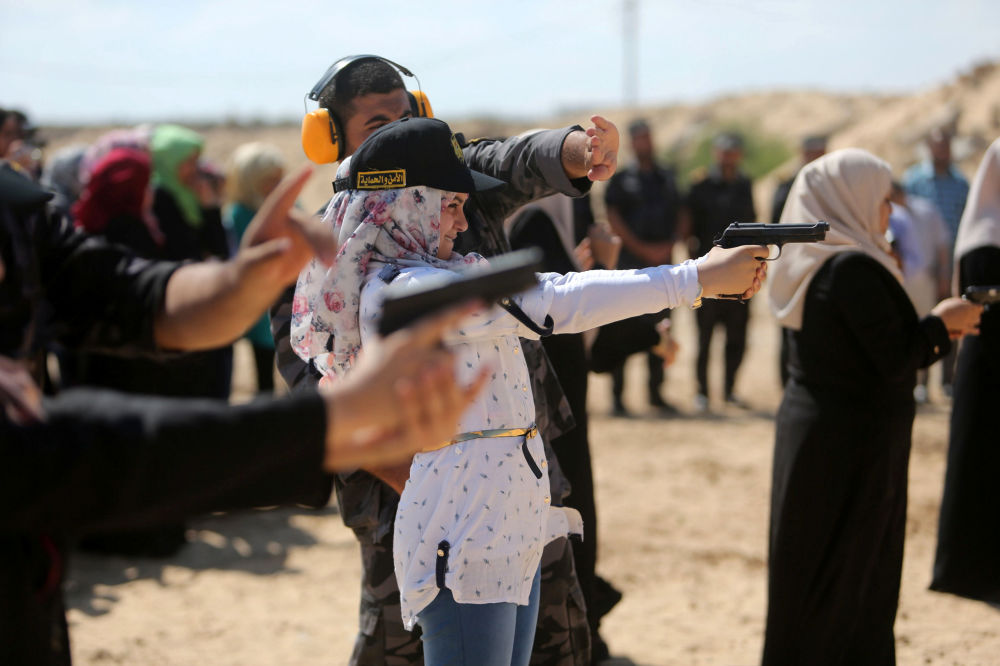 イスラム運動体「ハマス」メンバーの家族のための訓練でピストルを撃つ女性　パレスチナ・ガザ地区。